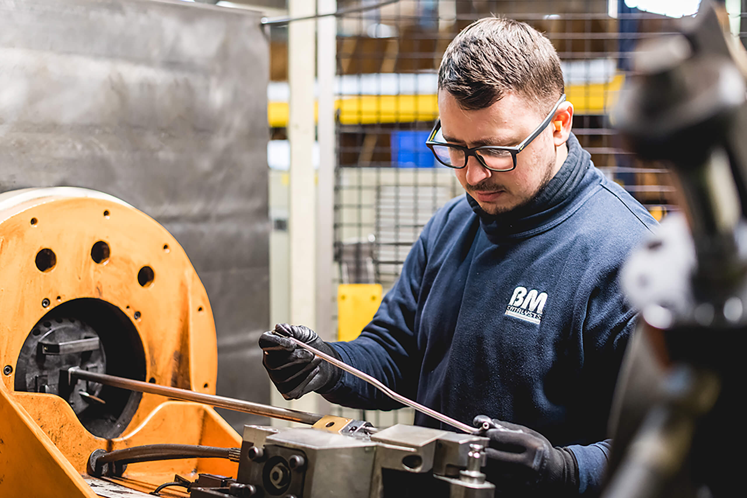 A BM Catalysts worker is inspecting a product part in the warehouse