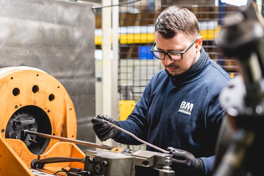 A BM Catalysts worker is inspecting a product part in the warehouse