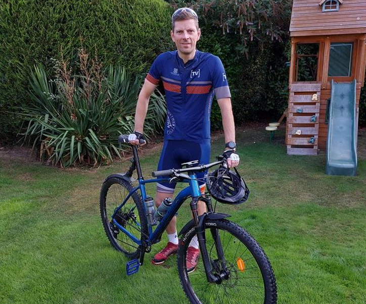 Commercial Director of BM Catalysts Mark Blinston is stood with a bike as he set off to do a off-road bike challenge