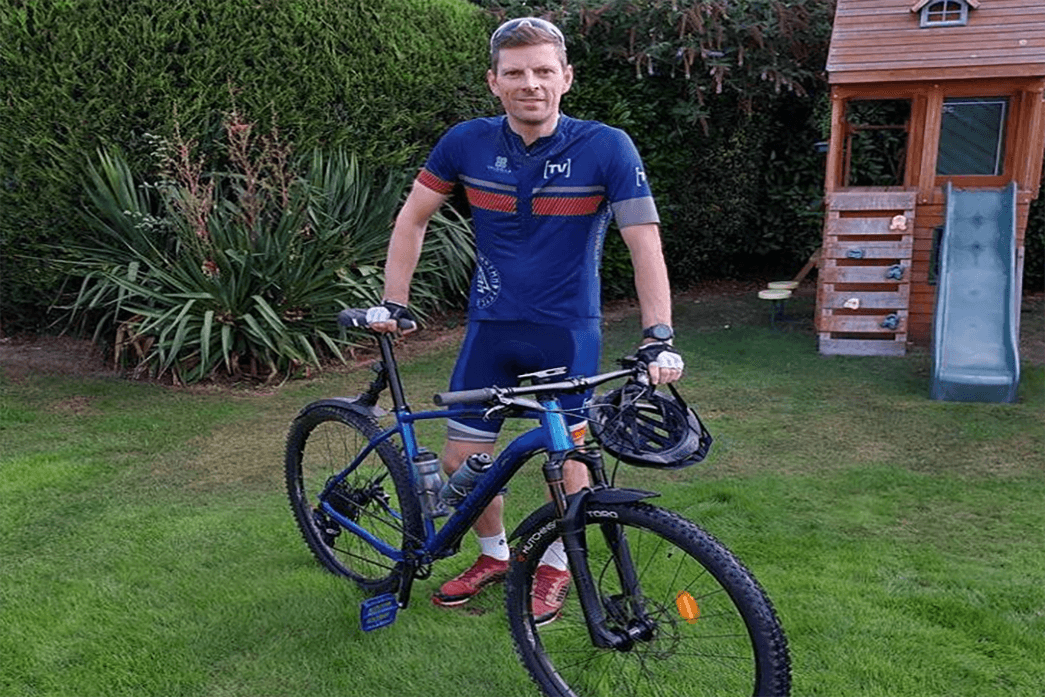Commercial Director of BM Catalysts Mark Blinston is stood with a bike as he set off to do a off-road bike challenge