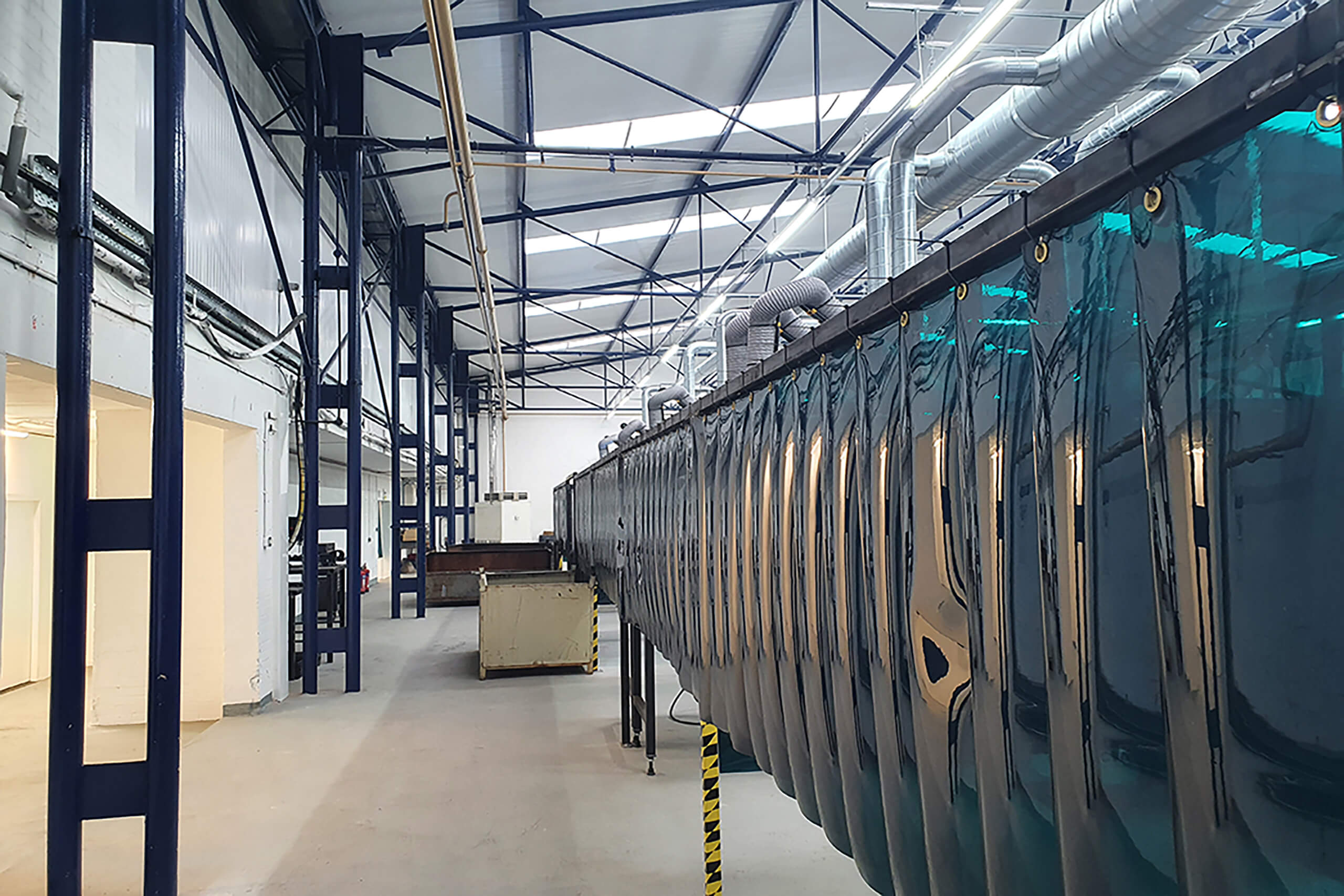 Welding curtains are hung in a factory setting