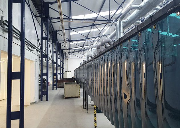 Welding curtains are hung in a factory setting