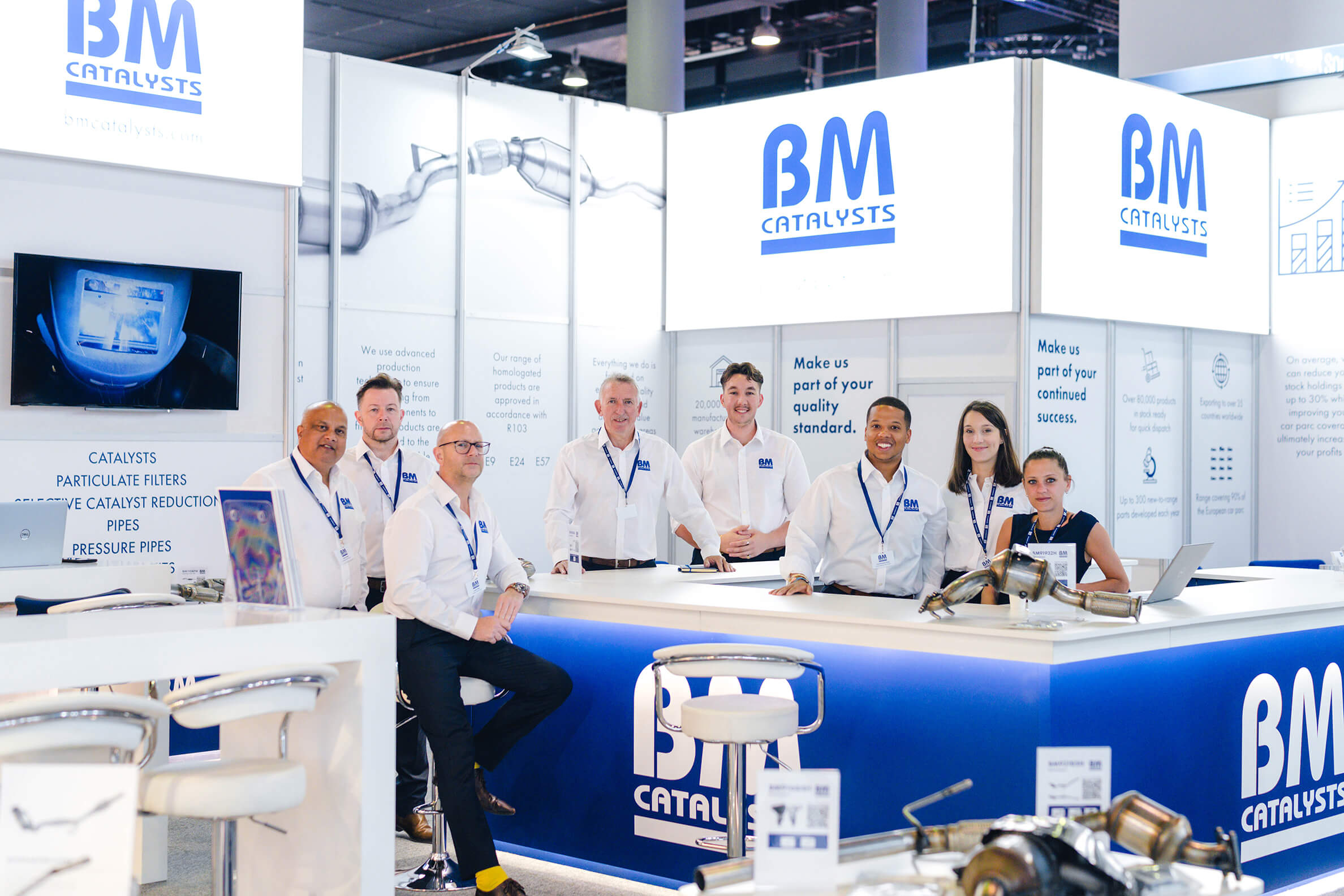 The BM Catalysts team pose in their exhibition stand for Automechanika.